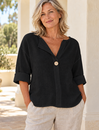 Zamma Relaxed V-Neck Top in black, styled on a mature woman in a light summer setting